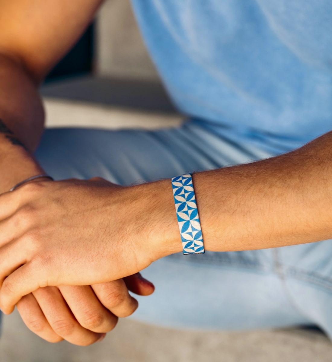 Elastisches Armband von Goodbands aus der "balance" Kollektion in blau und creme mit mediterranem Kachelmuster, getragen von einem Mann