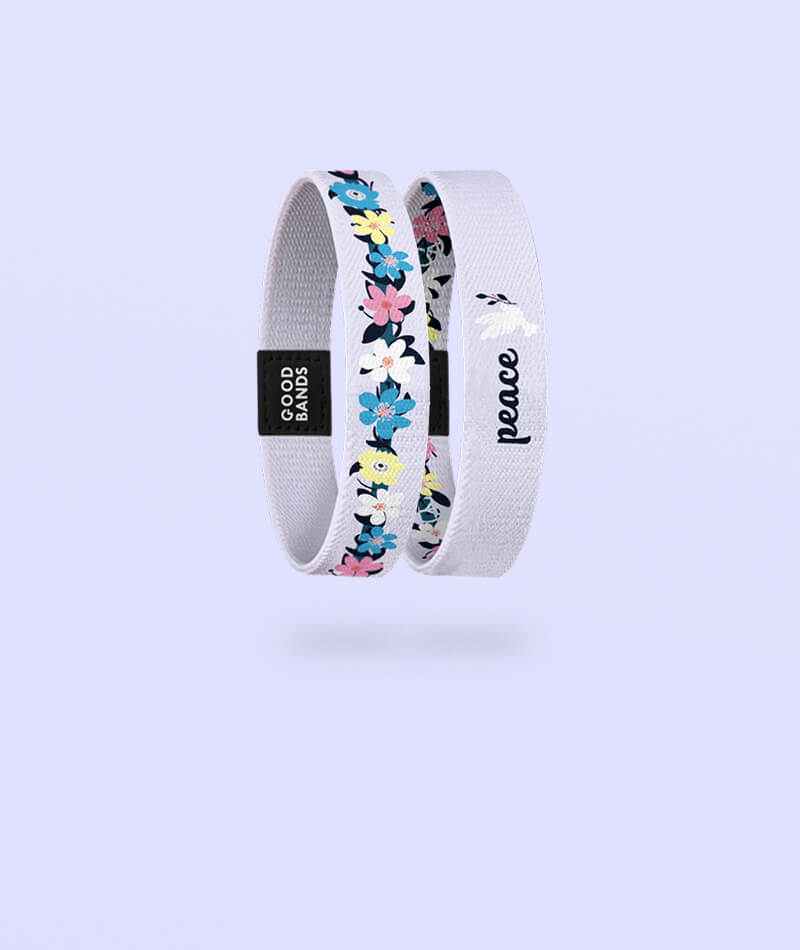 Elastisches Armband von Goodbands aus der "peace" Kollektion in flieder mit Blumenmuster, freigestellte Innen- und Außenseite vor hellem Hintergrund