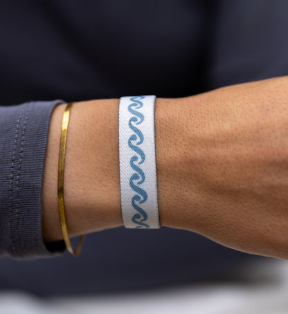 Modernes Armband von Goodbands aus der "airwaves" Kollektion mit skandinavischem Muster in grau-blau, am Handgelenk von einer jungen Frau