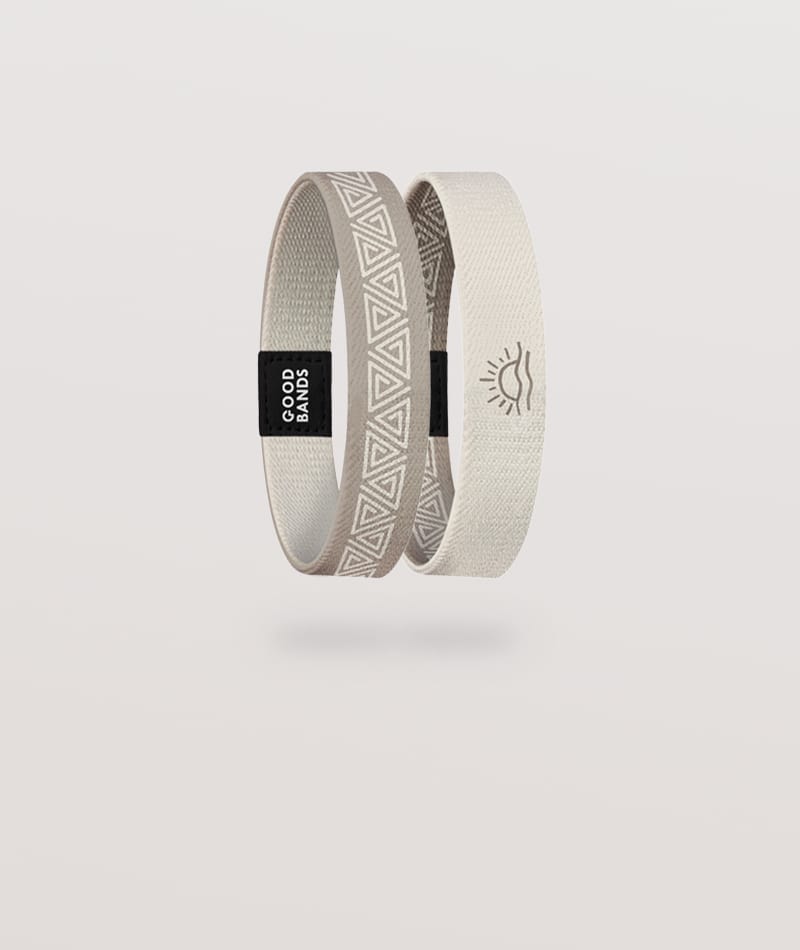 Elastisches Armband von Goodbands aus der "dune" Kollektion in beige-braun mit geometrischem Muster und Sonnensymbol, freigestellte Innen- und Außenseite vor hellem Hintergrund