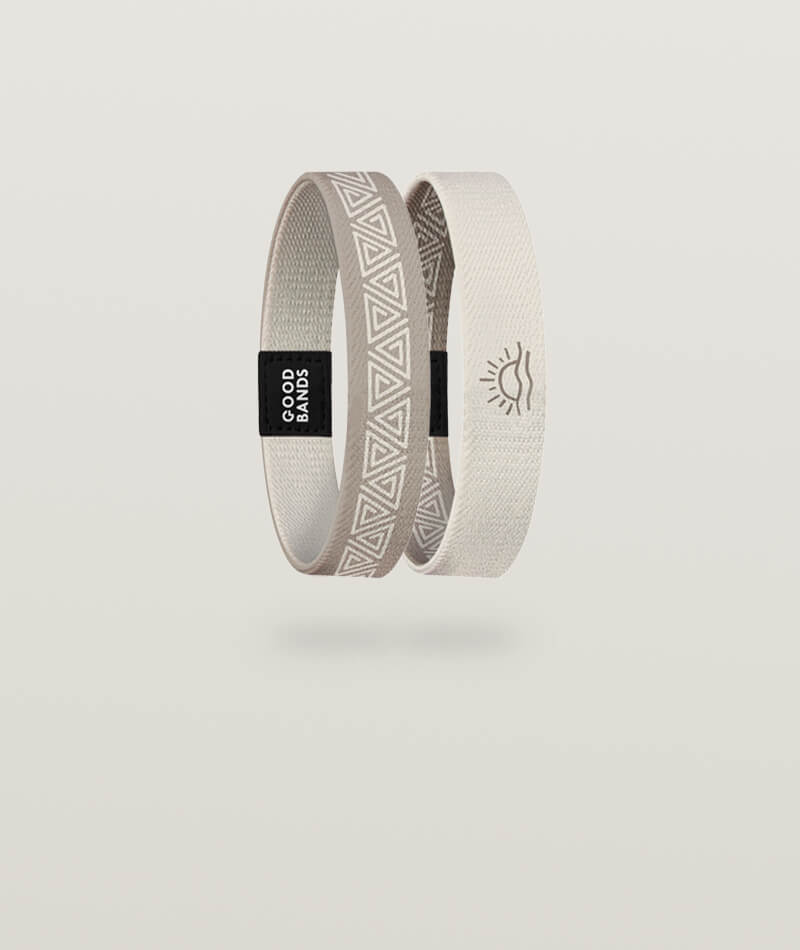 Elastisches Armband von Goodbands aus der "dune" Kollektion in beige/braun mit Sonnensymbol und geometrischem Muster, freigestellte Innen- und Außenseite vor hellem Hintergrund