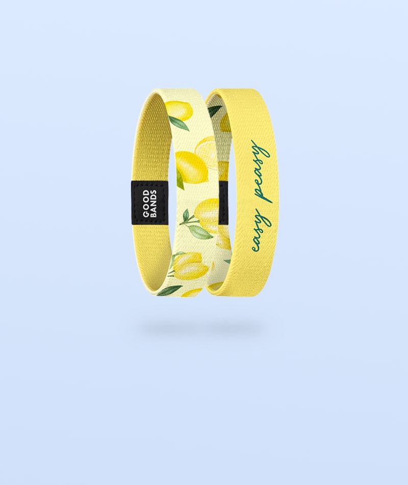 Elastisches Armband von Goodbands aus der "easy peasy" Kollektion in gelb mit Zitronenmuster, freigestellte Innen- und Außenseite vor hellblauem Hintergrund