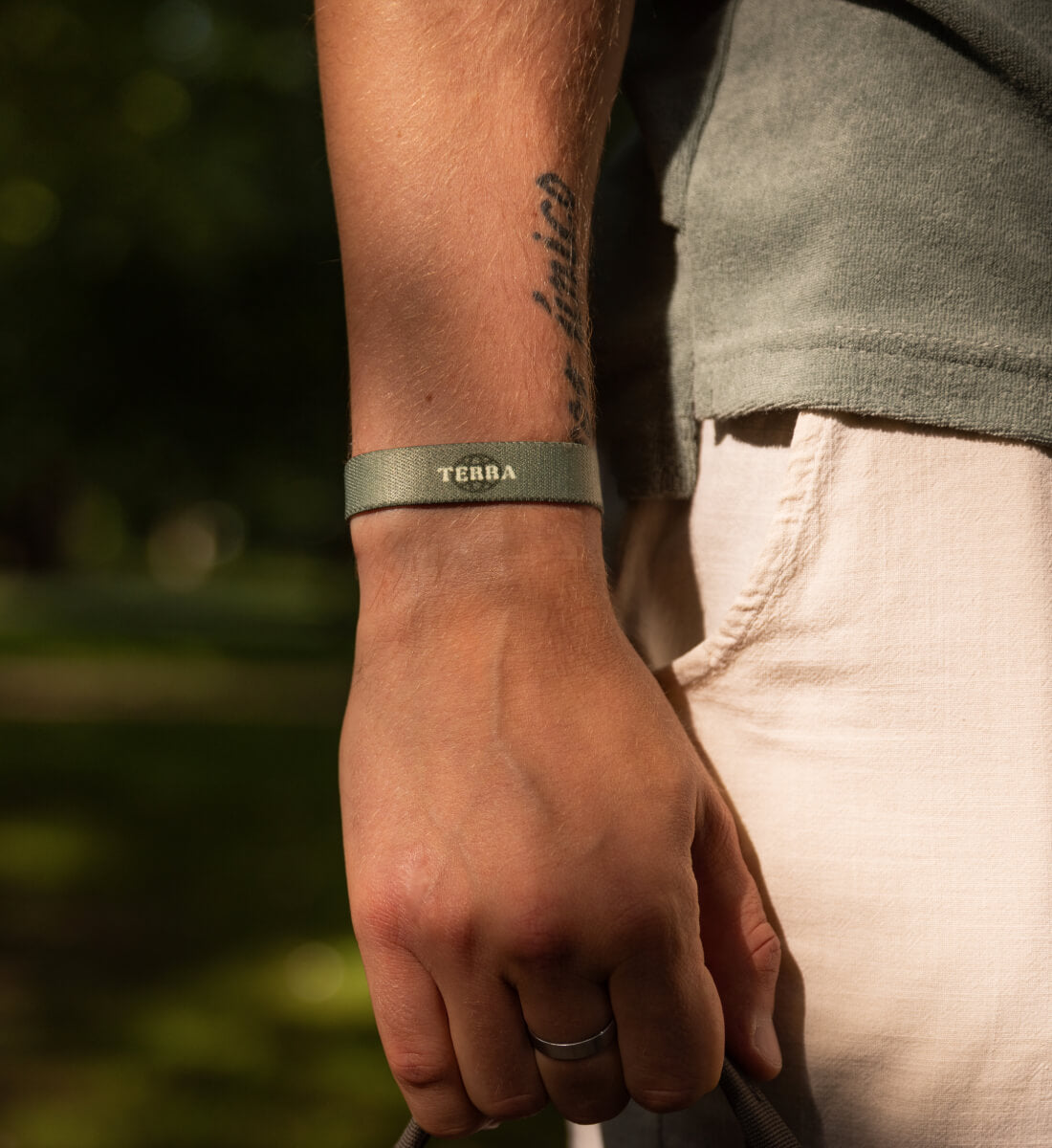 Elastisches Armband von Goodbands aus der "terra" Kollektion in grün-olive mit Linien-Muster, am Handgelenk getragen