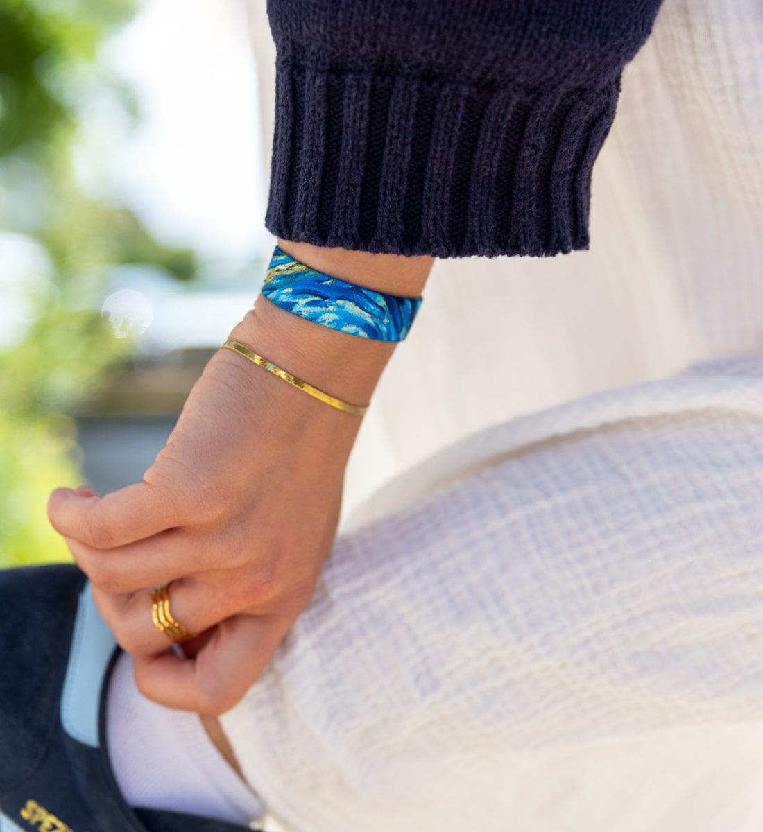 Elastisches Armband von Goodbands aus der "unique" Kollektion in blau-gold mit Wellen-Muster, am Handgelenk getragen