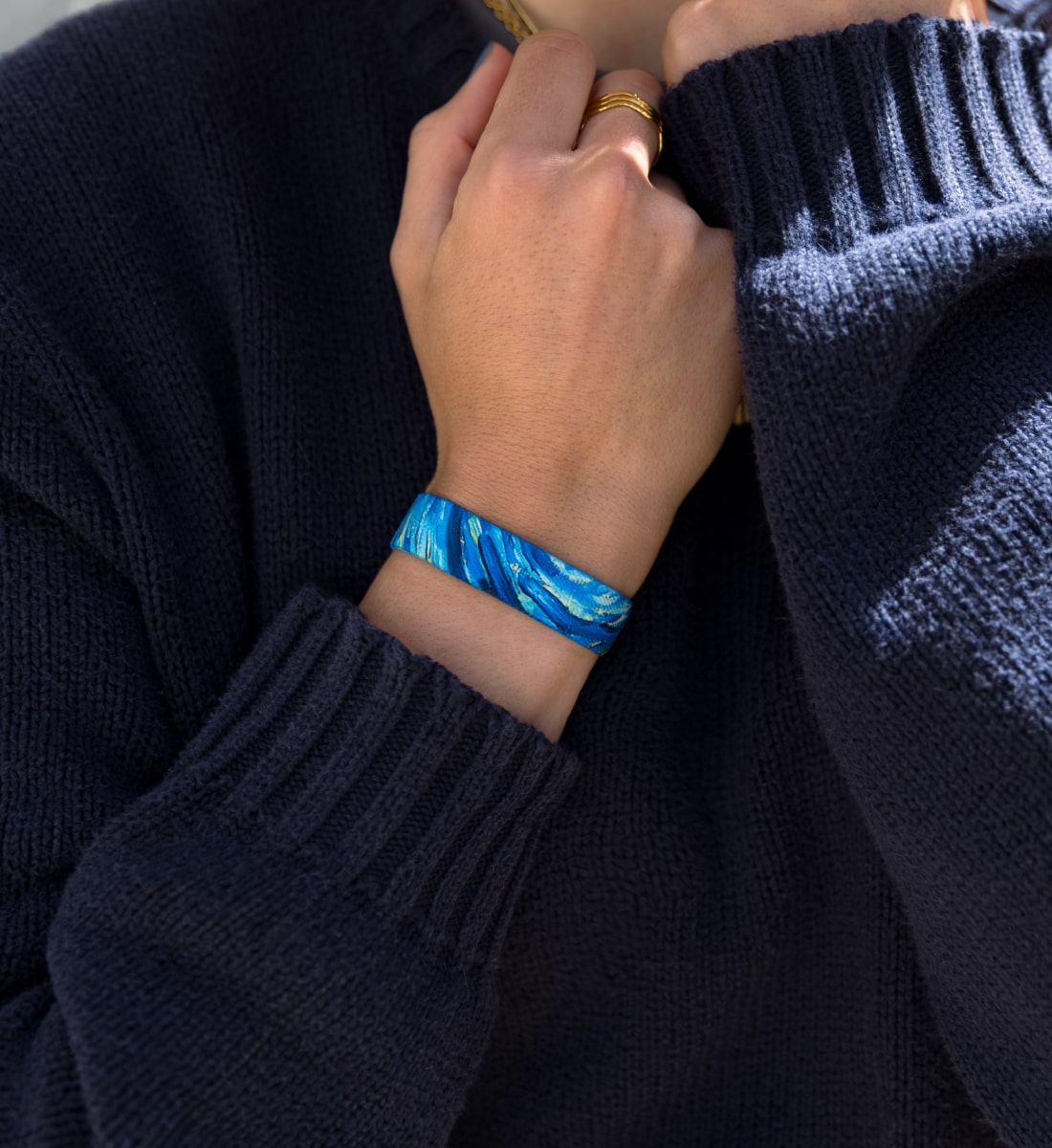 unique Armband von Goodbands in blau-gold mit Wirbel-Muster, getragen im Alltag